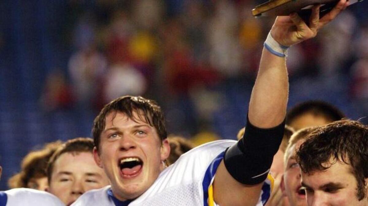 Ferndale's Jacob Locker (10) holds up the school trophy for fans to see over Mitch Johnson's head after the 47-12 win over Prosser in the state 3A football championship game in Tacoma, Wash., on Friday, Dec. 2, 2005.