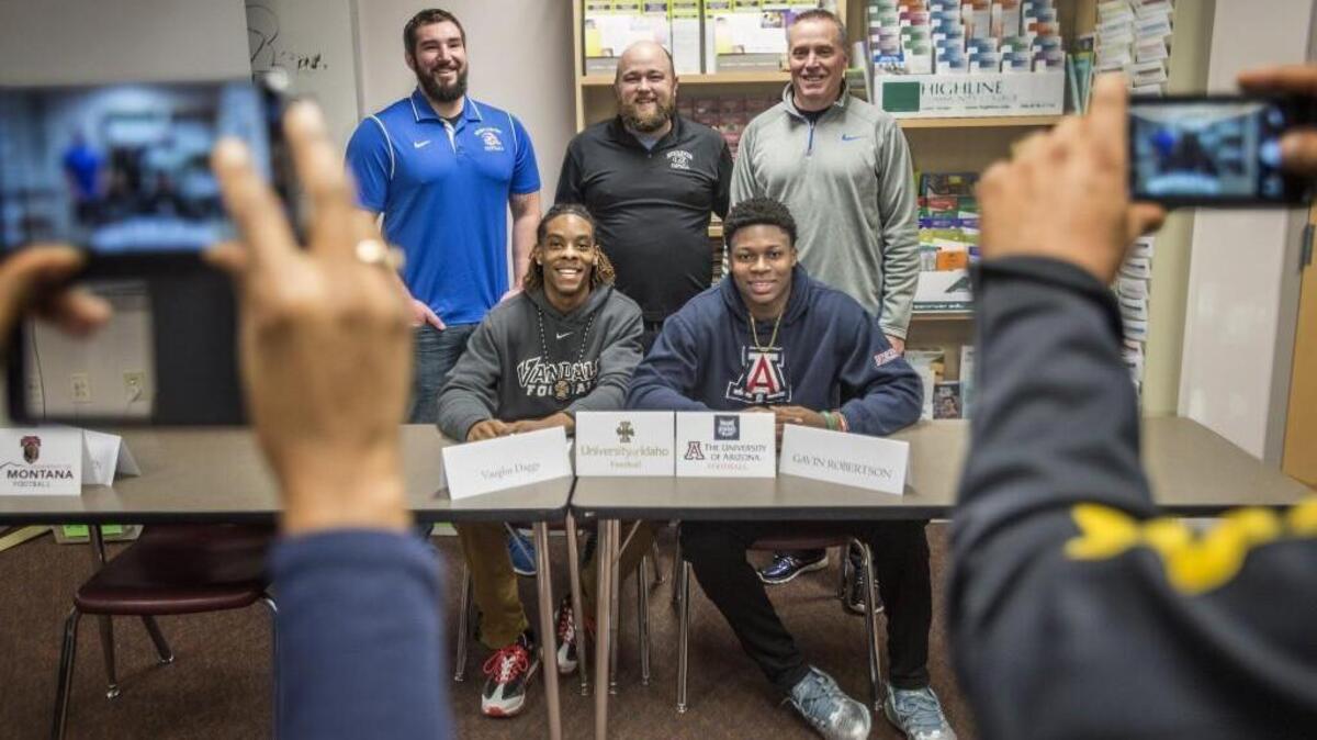 Auburn Mountainview’s Gavin Robertson, lower right, poses with fellow player Vaughn Daggs, left, and quarterbacks coach Eric Jarvis, upper left, head coach Jared Gervais, center, and defensive coordinator Kent Rodseth after signing with the University of Arizona. Robertson was the first football player from the school to ever sign with a Division I school.