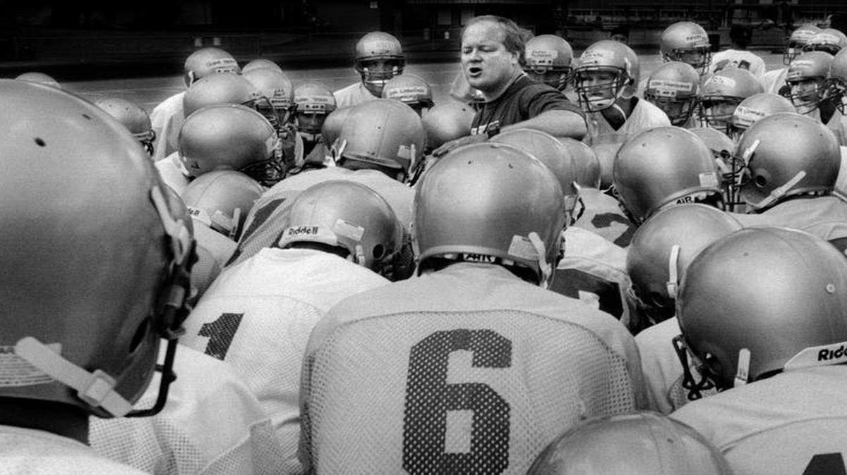 Auburn H.S. head coach Bob Jones (center) is payed homage by his players as he barks out practice orders during the first day of practice at the high school.