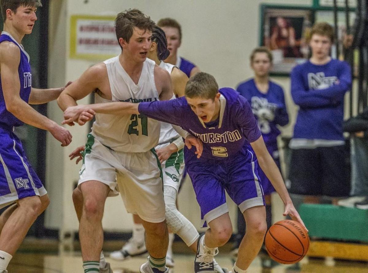 North Thurston guard Jeremy Spencer (2), right, dribbles around pressure by Peninsula guard Jared Brinkmann (21). The Peninsula High School Seahawks ends the North Thurston High School Rams's undefeated run with an emphatic 56-48 win in Purdy, Wash., Thursday, Feb. 1, 2018.