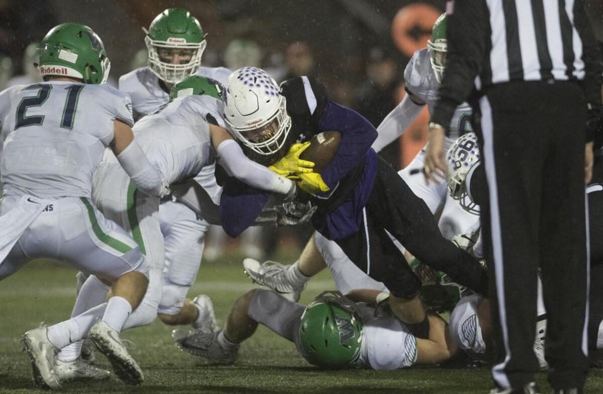 Sumner running back Ben Wilson fights for extra yards against the Woodinville defense during the 4A state football semifinal at Sparks Stadium in Puyallup on Nov. 25, 2017.