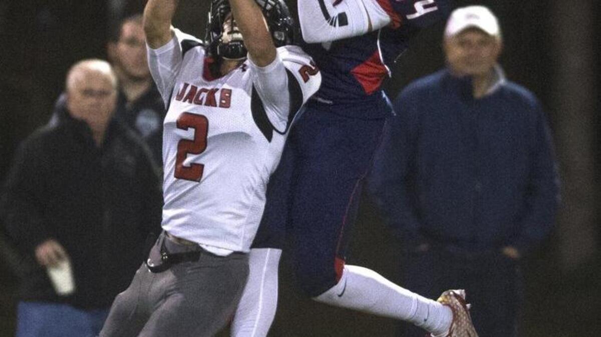 Black Hills wide receiver Jewell Day (34) makes a juggling catch over R.A. Long defensive back Riley Opgrande during Saturday's 2A district playoff football game at Tumwater District Stadium on Nov. 7, 2015.