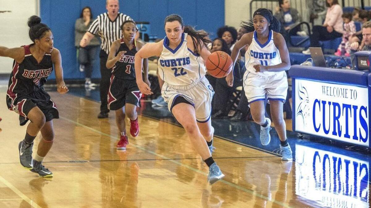 Curtis’s Haley Marsh leads a fast break Thursday for Curtis defended by Tianna Brown of Bethel, at left, in a first-round matchup in the 4A West Central District tournament won by Curtis, 44-34.