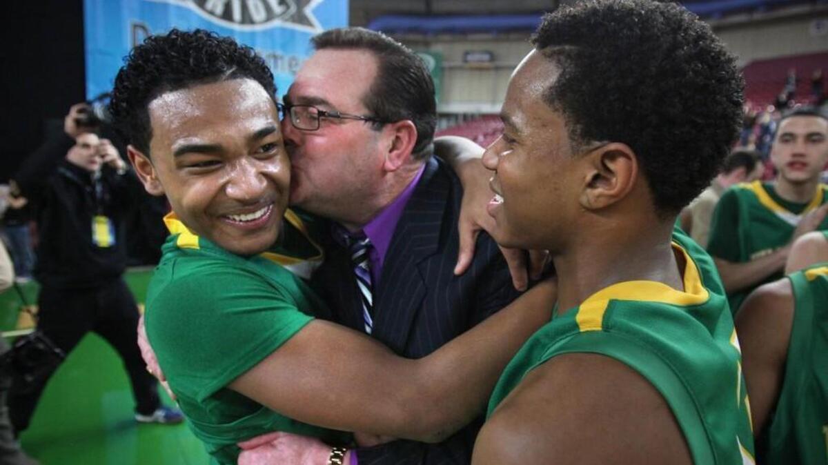 Clover Park head coach Mel Ninnis plants a kiss on the cheek of freshman guard David Crisp following the Warriors’ 2A boys basketball state championship win over Squalicum in the Yakima Valley SunDome on Saturday, March 5, 2011. (Tony Overman/Staff Photographer)