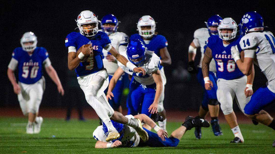 Graham-Kapowsin quarterback Joshua Wood scrambles for a first down as Bothell linebacker Conner Tompkins Delacerda attempts to tackle him late in the second quarter of a State 4A quarterfinal game on Friday night at Art Crate Field in Spanaway.