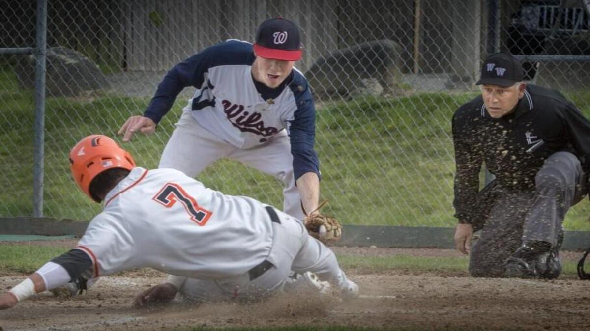 Home plate umpire watches closely as Wilson pitcher Ethan Denney tags out Central Kitsap's Kendal Yeagle at home plate in the first inning at Wilson High School on Wednesday, Apr. 13, 2016.