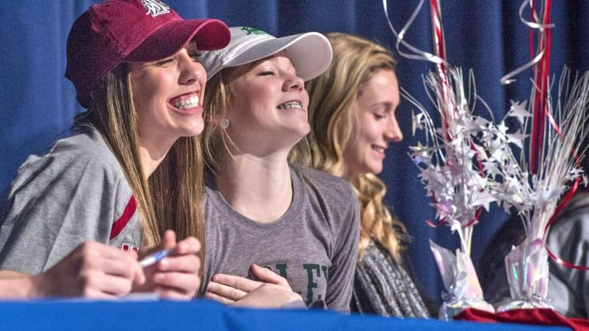 Morgan Weaver, left, a three time News Tribune All-Area Soccer player of the year is all smiles during a signing day ceremony at Curtis High School on Wednesday. Weaver and schoolmate Torrey Tompkins flashed their purely whites for family keepsake photos after the ceremony.