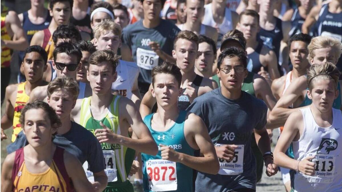 Race winner Luke Schilter (3872) of Northwest Christian runs in a crowd early in the senior boys race Saturday at the Capital Cross Country Invitational meet on the Capital High School. Schilter became the only four-time winner of the event, but he’s still looking for his first state title.