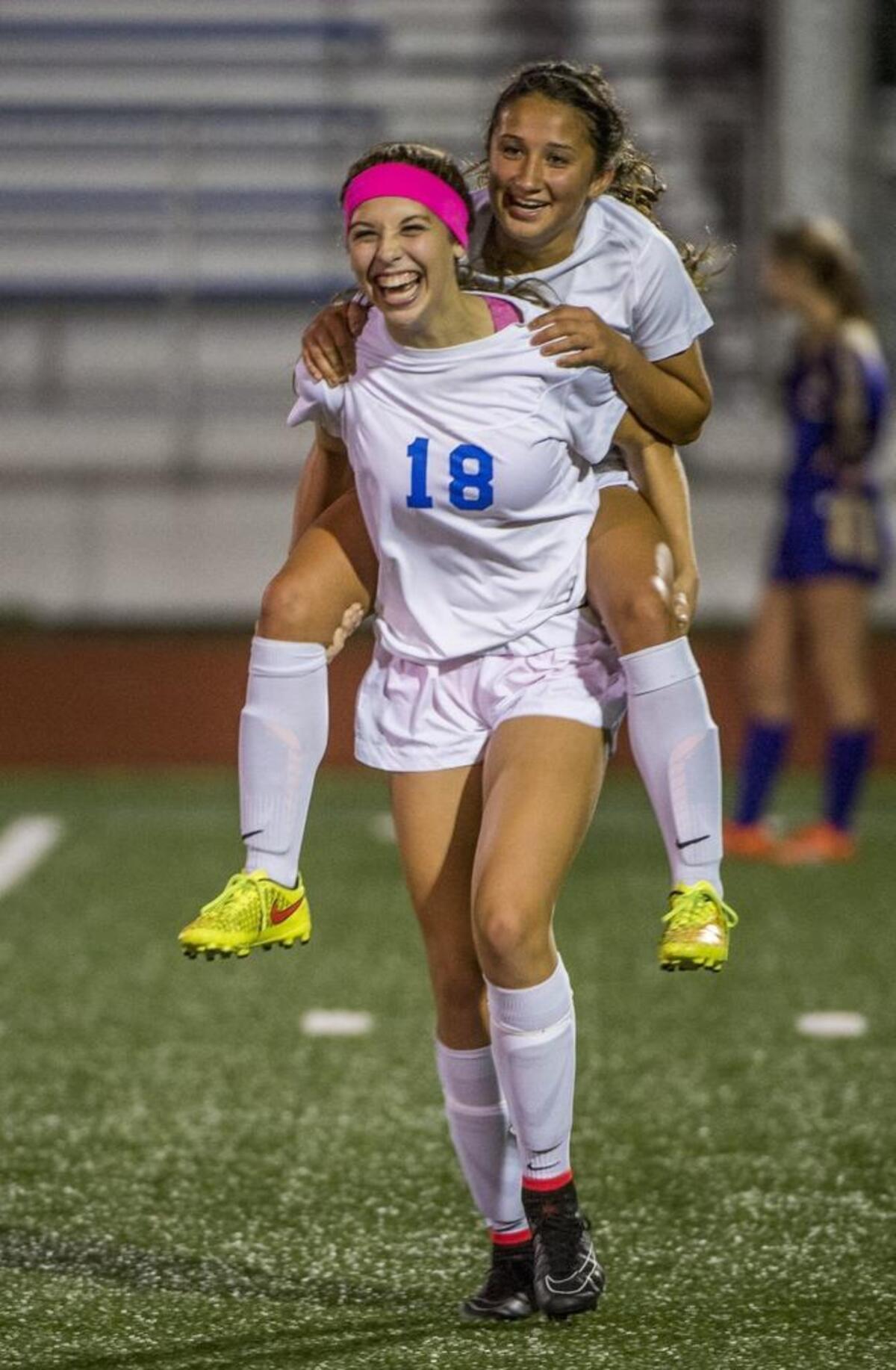 With minutes to go in the game, Morgan Weaver of Curtis High School has the extra energy to carry an ailing Sariah Keister off the pitch in a girls soccer match at Curtis High School that decided the league championship, October 21, 2014. Curtis beat Puyallup 3-2.