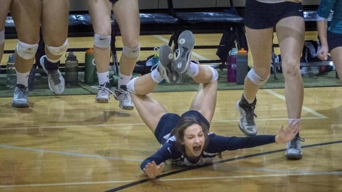 Auburn Riverside's Camden Heilborn dives to the ground to celebrate Ravens 3-2 set win over Bellarmine Prep at Kentwood High School on Saturday, Nov. 5, 2016.