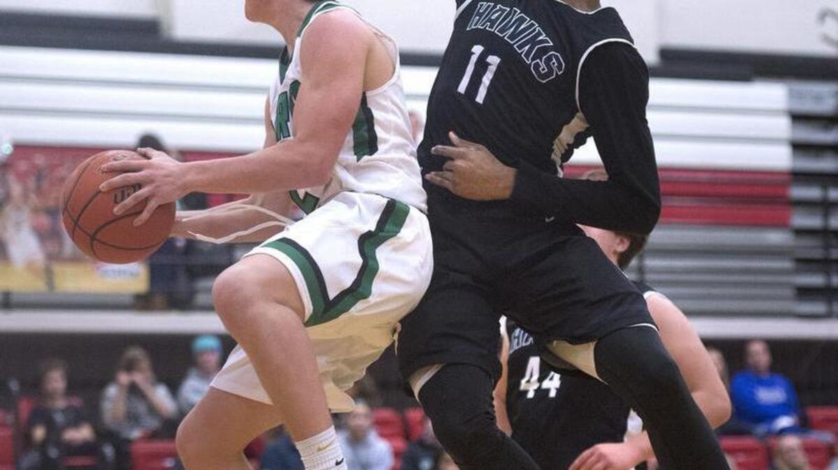 Tumwater’s Andrew May, left, flies to the basket against River Ridge’s Jordan Skipper-Brown on Thursday. Led by Thomas Drayton, who scored a team-high 18 points, the T-Birds grabbed an early lead and held it.