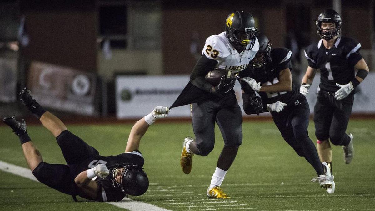 Lincoln freshman Julien Simon (23) runs through multiple tackles in the third quarter. The Abes played Bonney Lake in a football game at Sunset Chev Stadium in Sumner, Wash., on Friday, Oct. 20, 2017.