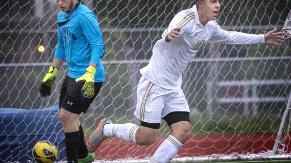 Puyallup's Tyler Wood, right, celebrates scoring the game's first goal as Curtis goalkeeper Brady Kelly retrieves the ball at Sparks Stadium on Tuesday, Apr. 26, 2016.