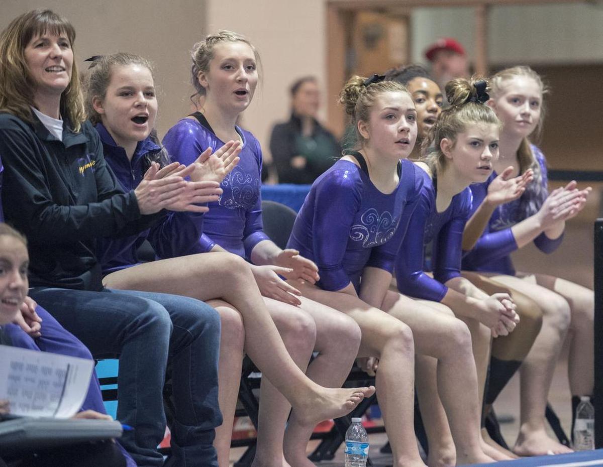 The Puyallup gymnastics team cheers a teammate during the floor exercise. Photo taken in Tacoma on Friday, Feb. 17, 2017.