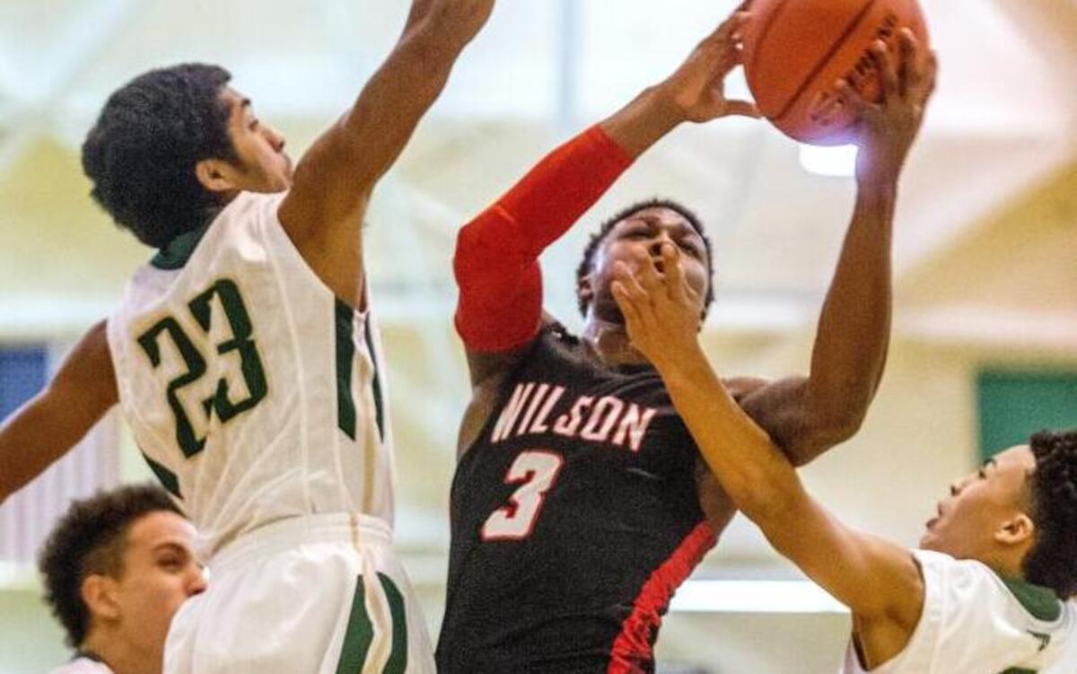 Wilson guard David Jenkins Jr. (3) attempts a shot against the defense of Timberline’s Mika Allison,left, Jake Williams (23) and Casson Rouse (5) on Saturday at Highline College in Des Moines.