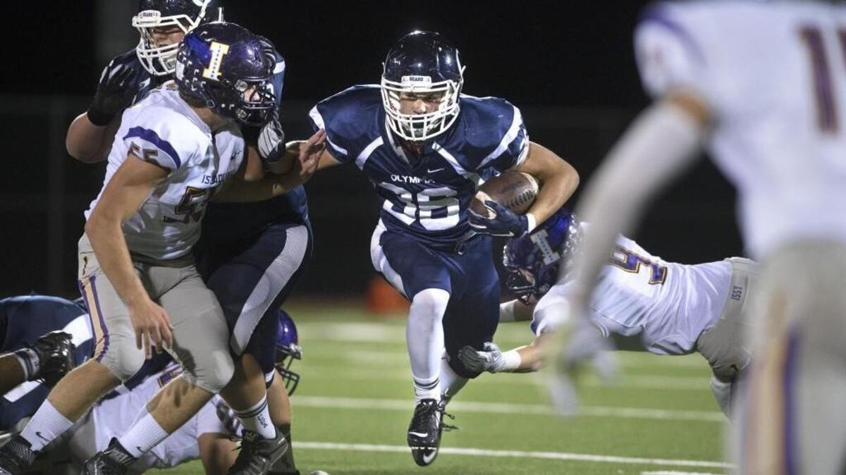 
Olympia running back Scott Gunther finds a hole between Issaquah defenders Laurence Donohue, left, and Kyle Densley (9) during the Bears’ 32-14 win Friday night at Ingersoll Stadium. Gunther’s 1,081 yards and 16 touchdowns have helped lead Olympia to its first 5-0 start since 2011.
