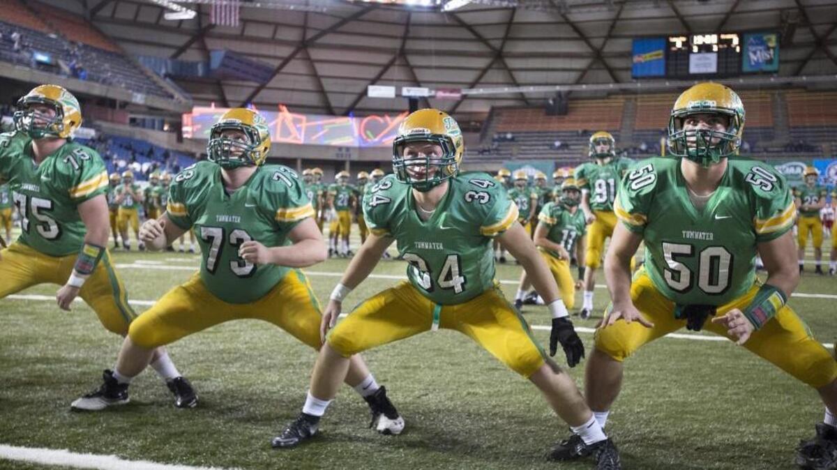 Tumwater players, from left, Bailey Snow, Dakoda Keller, Caleb Jelcick and Cy Hicks run through warmups before their 2A football state championship game against the Prosser Mustangs in the Tacoma Dome on Saturday, Dec. 5, 2015.