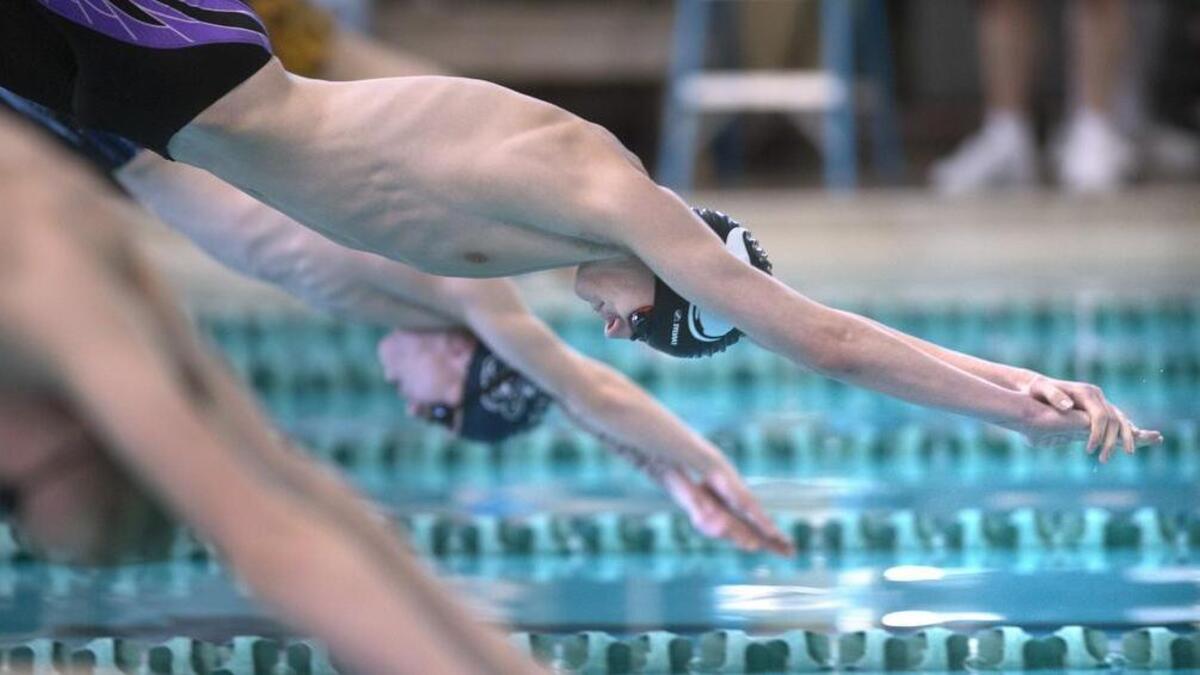 Puyallup junior Bryan Chappell and Olympia freshman Ben Kosa (background) take off at the start of the 2 X 200 yard freestyle relay at the South Sound Relays swimming meet at The Evergreen State College in Olympia on Saturday, Jan. 14, 2017.