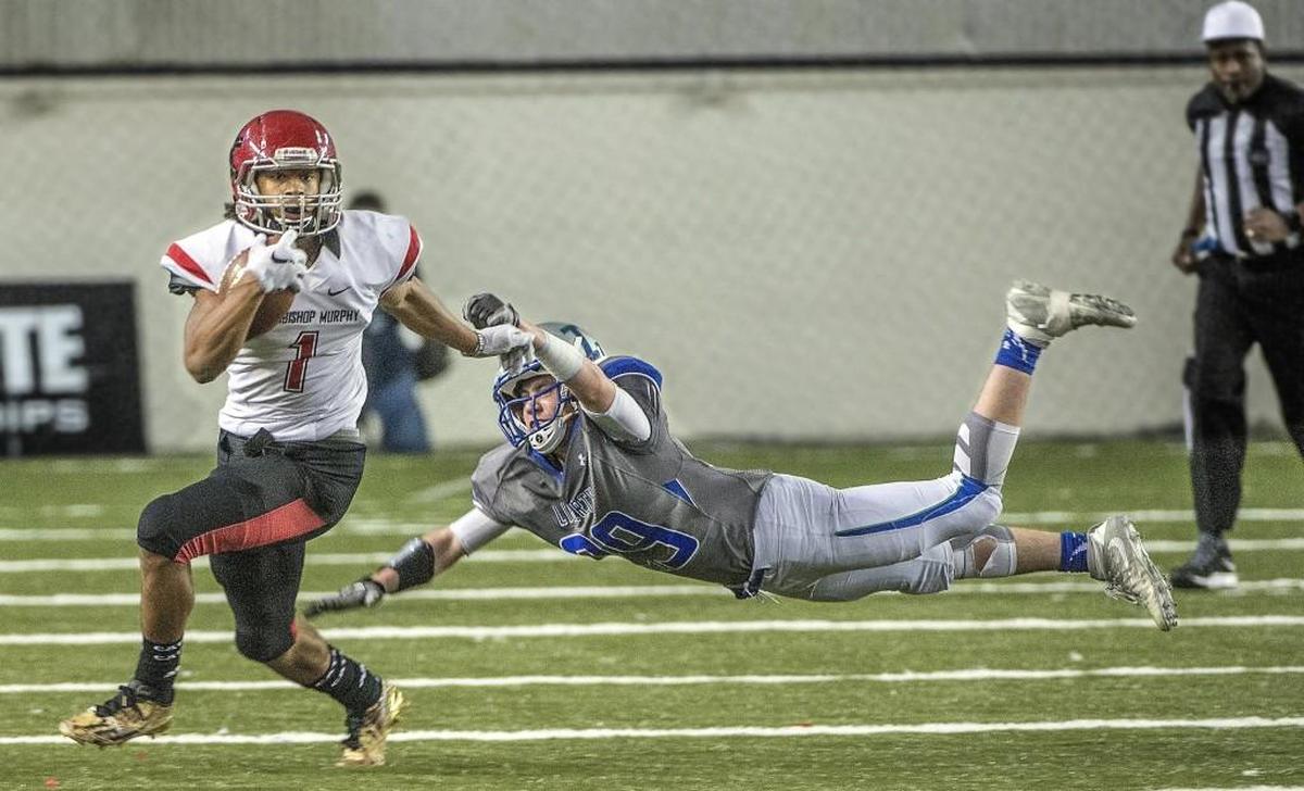 Arch Bishop Murphy's wide receiver Kyler Gordon, left, eludes Liberty strong safety Jake Wright's diving tackle attempt for a long second half gain Saturday at the Tacoma Dome. Archbishop Murphy finished with a perfect record and the title in a blowout win 56-14 over Liberty H.S. of Issaquah.
