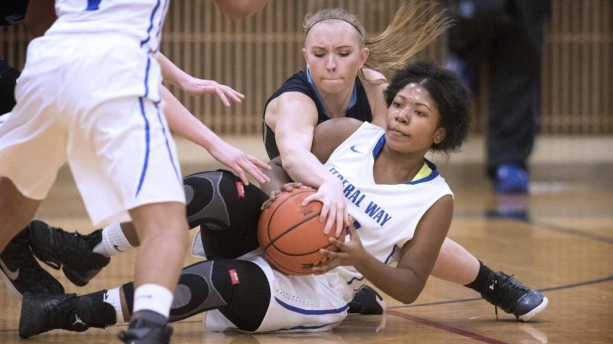 Olympia defender Carly Carlson (top) harasses Federal Way's Jhordyn Duell during Thursday night's 4A Girls West Central District III basketball playoff game at Federal Way High School on Feb. 11, 2016.