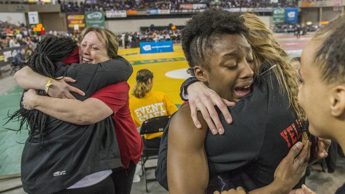 Phoenix Dubose of Yelm (right) is in tearful disbelief after winning the girls 115-pound weight class championship round of the Thirtieth Mat Classic state wrestling tournament held in the Tacoma Dome, February 17, 2018. He mom and coach hug at left.