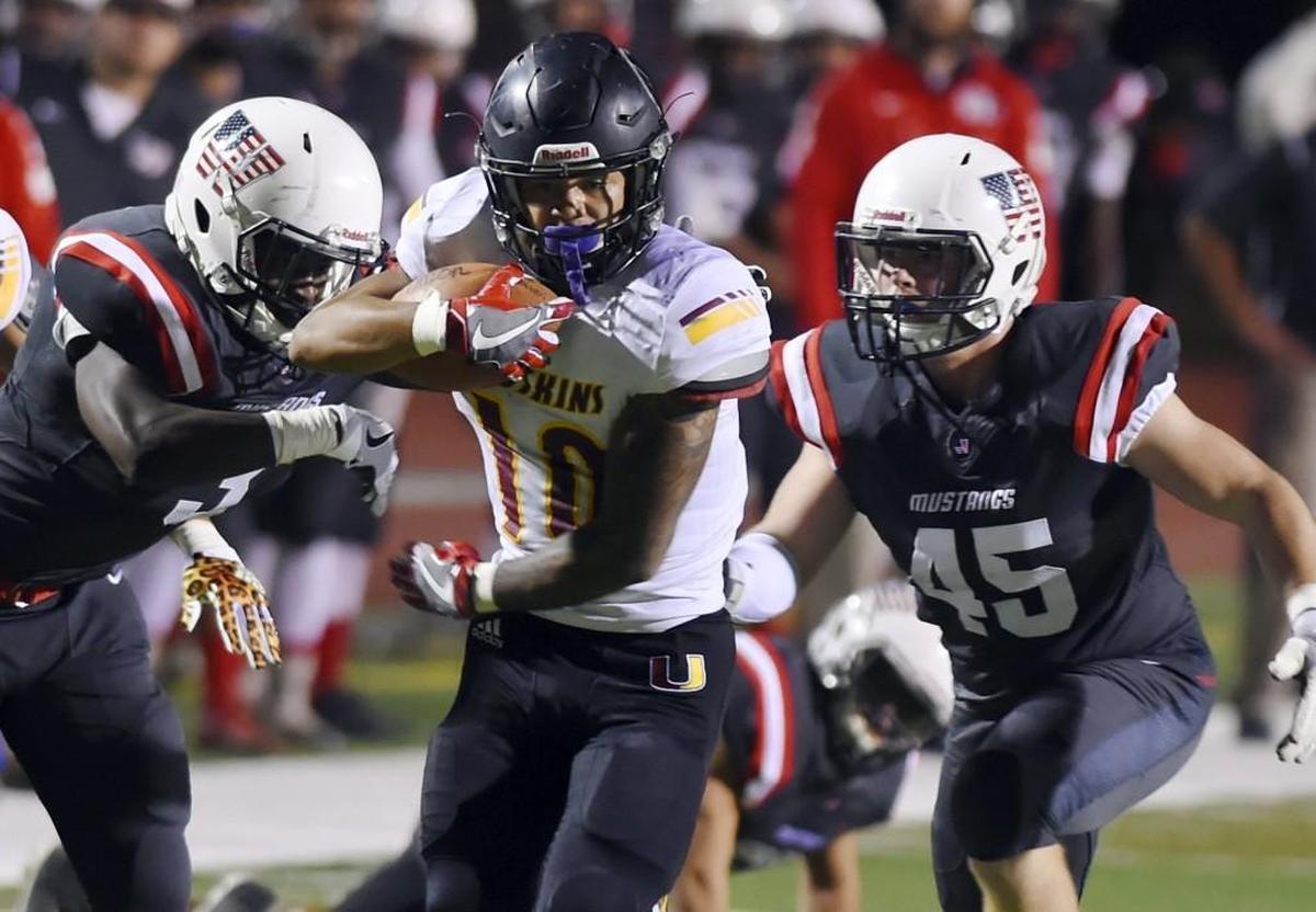Tulare Union running back Kazmeir Allen, center, is pursued by Tulare Western's Marlon Benson, left, and Tyler Loscutova, right, in first half Bell Game action Friday night, Oct. 3, 2017 in Tulare. Tulare Union led 35-14 at halftime.