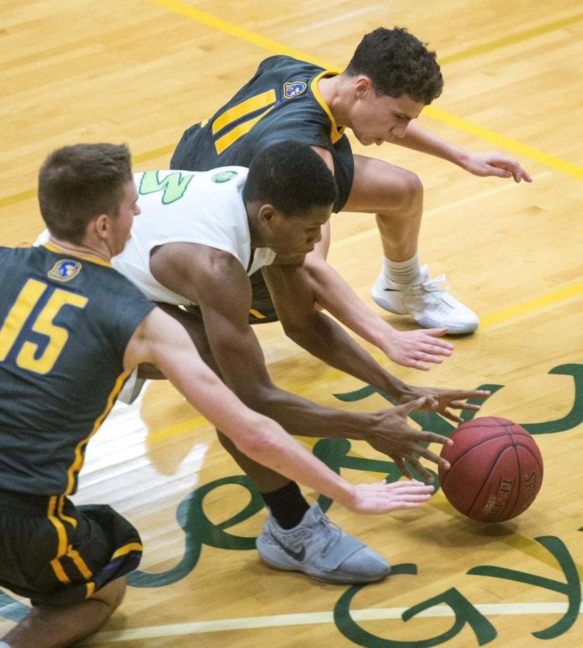Michael Pollard of Foss, center, battles Fife's Brian Mitchell and Malachi Afework for a loose ball. Pollard scored 16 points for the Falcons. Photo taken in Tacoma on Tuesday, Jan. 16, 2018.