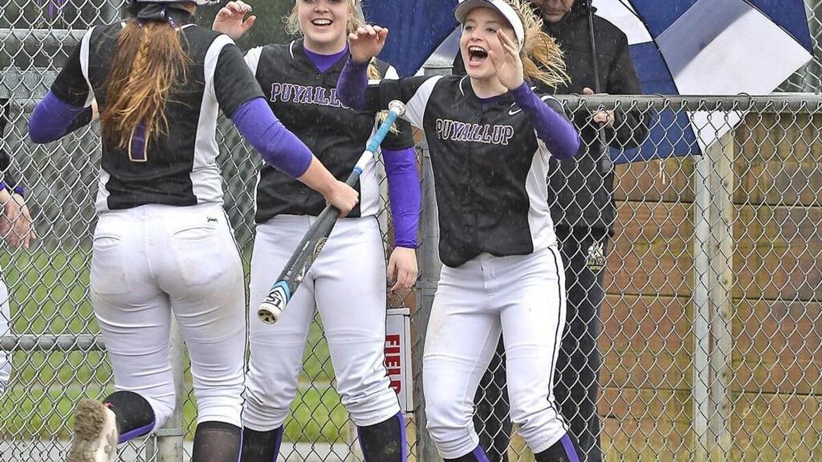 Puyallup pitcher Kennedy Robillard, center, and Natalie Joyner, right, welcome Sophia Bjerk left, into the dugout after the Vikings built a 3-0 lead in the first inning at Heritage Park in a game between league rivals Puyallup and Rogers H.S. Tuesday 5/02/1.