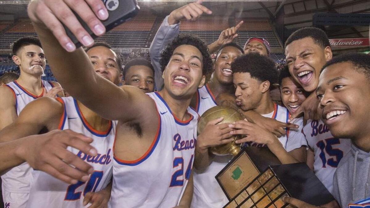Rainier Beach High's Marquis Gurski takes a selfie as teammates ham it up to the max Saturday following their dominant 70-49 victory over O'Dea to take the 3A state title in Tacoma.