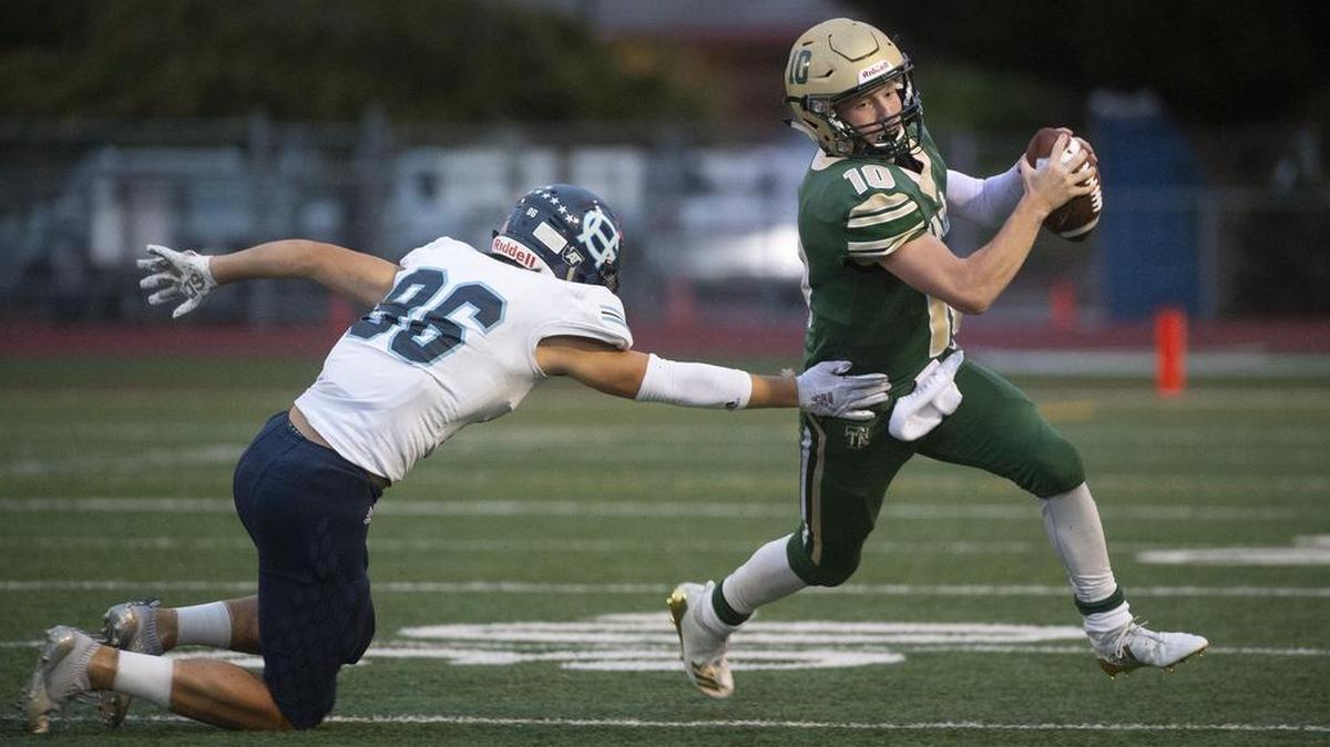 Timberline quarterback Hunter Campau slips away from Gig Harbor defender Tate Turnbull during Friday night’s football game at South Sound Stadium in Lacey on Sept.14, 2018.