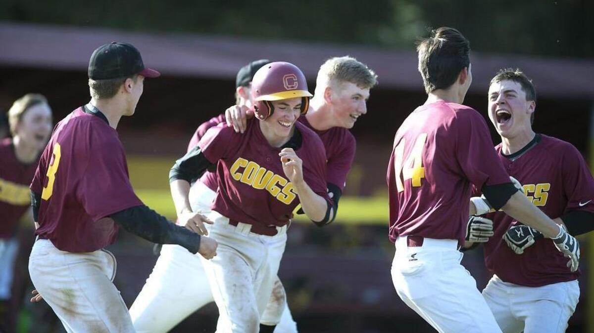 Capital players mob pinch runner Alex Halstead (in helmet) after he scored the winning run on a grounder by teammate Peyton Greene to defeat Central Kitsap, 1-0, on Wednesday afternoon.