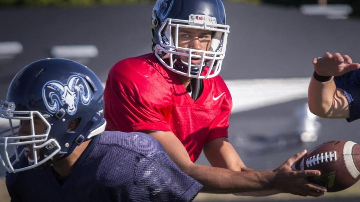 Rams quarterback J.J. Young hands off during practice at Mount Rainier High School in Des Moines on Wednesday.
