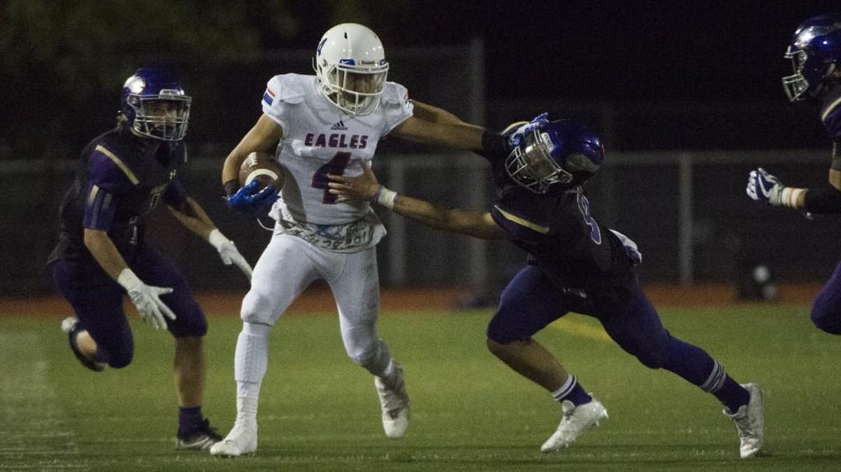 Graham-Kapowsin's Valentino Hansen (4) tries to break away from tackles in the fourth quarter. Graham-Kapowsin played Puyallup in a football game at Sparks Stadium in Puyallup, Wash., on Thursday, Oct. 5, 2017.