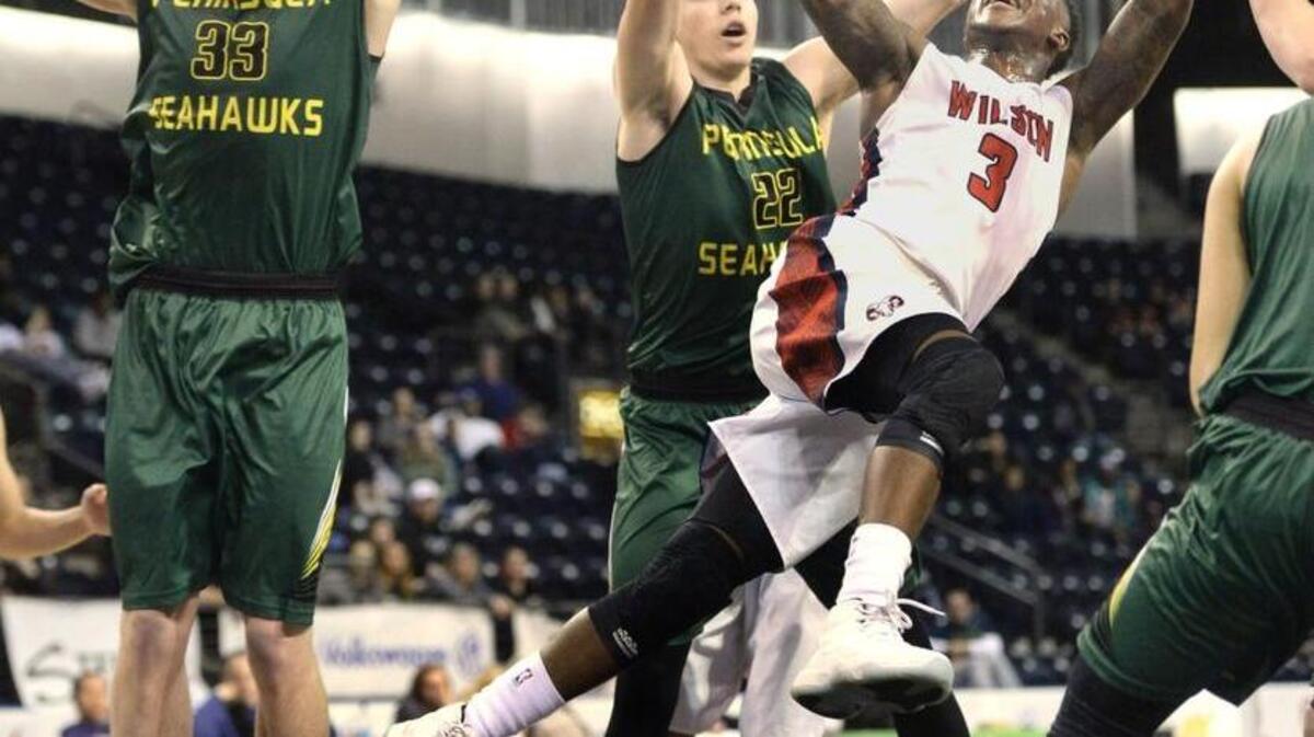 Wilson's David Jenkins Jr., who lead all scorers with 28 points, soars between Peninsula defenders Austin Kingman, left, and Garrett Kingman in the second half. The Seahawks prevailed over the Rams, 63-61. Photo taken at Showare Center in Kent on Saturday, Dec. 19, 2015.