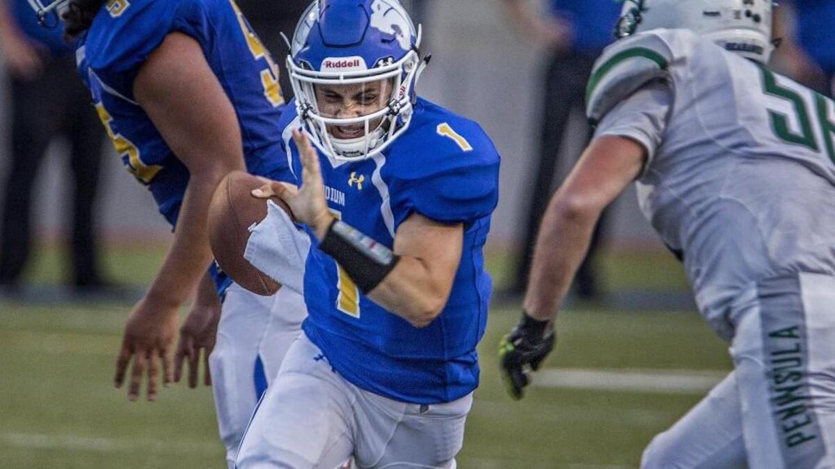 Stadium quarterback Hunter Wendling avoids Peninsula defenders in last week’s game. The Tigers, behind Wendling, made the playoffs last year for the first time in school history.