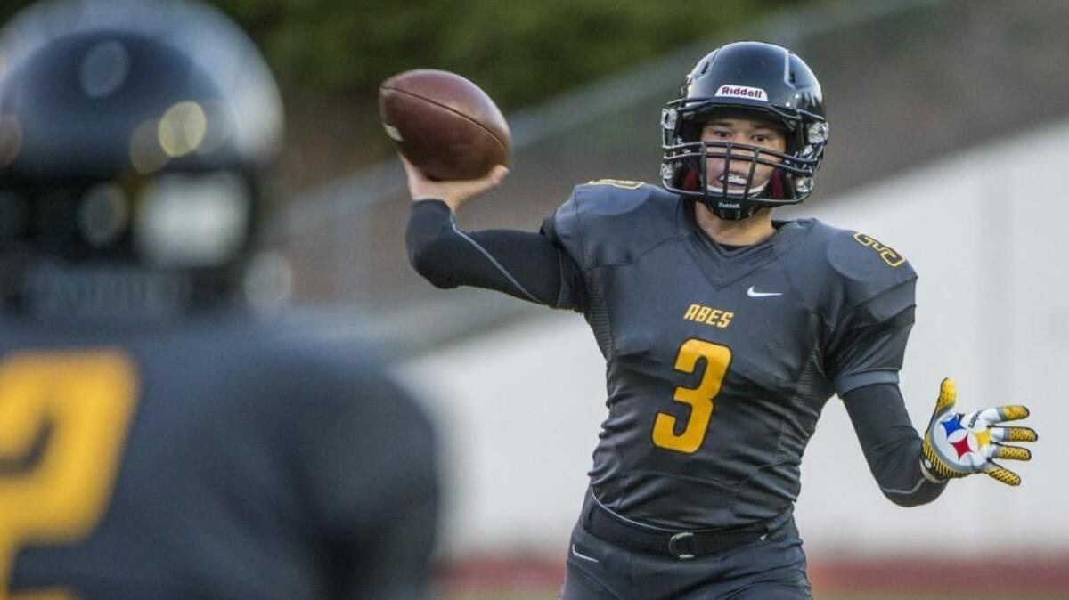 Former Lincoln quarterback Jordan Kitna, who is walking on at Michigan State, throws in a game against Puyallup at Lincoln Bowl in Tacoma on Sept. 12, 2014.