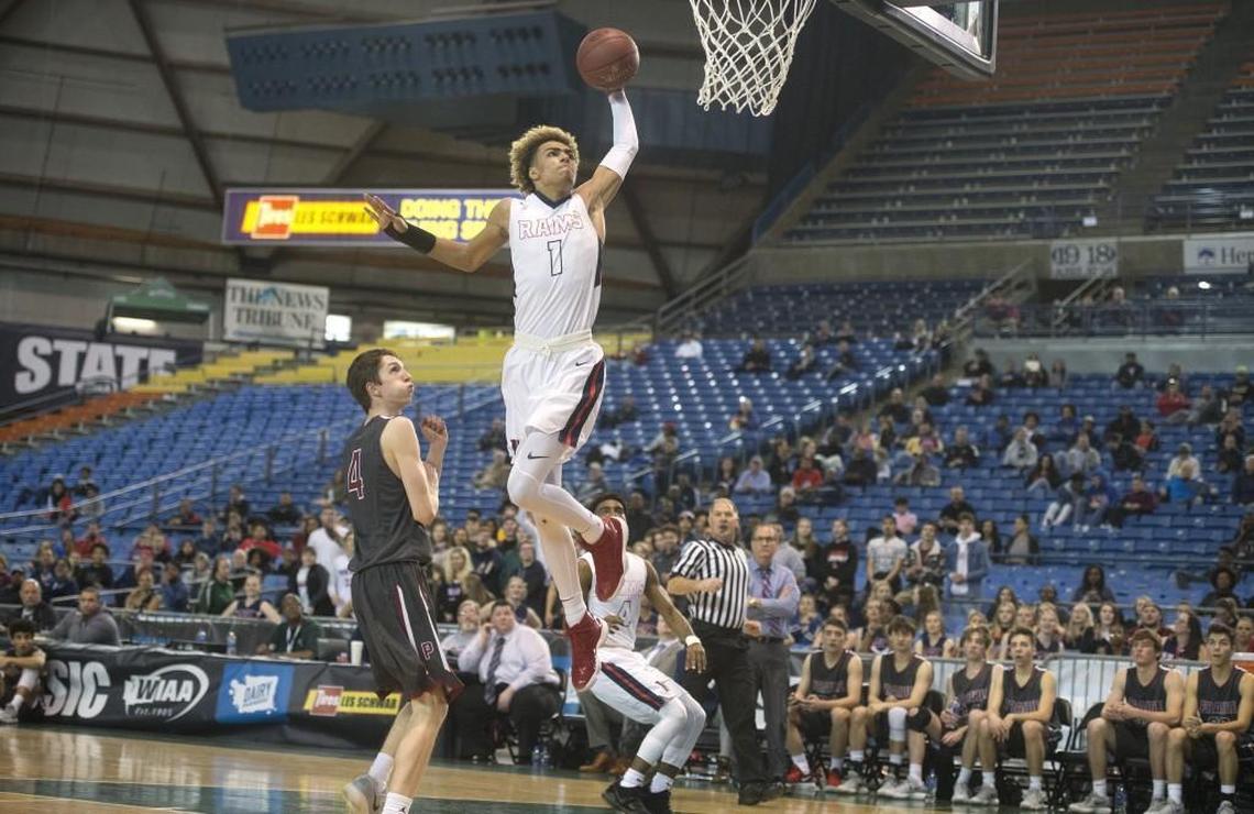 Wilson senior Emmitt Matthews Jr. skies for a breakaway dunk in front of Prairie defender Braiden Broadbent during Wednesday's opening-round game of the 3A boys basketball state tournament in the Tacoma Dome on Feb. 28, 2018.
