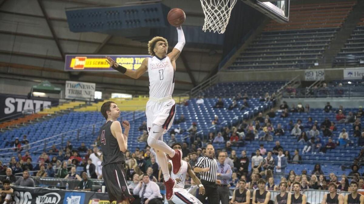 Wilson senior Emmitt Matthews Jr. skies for a breakaway dunk in front of Prairie defender Braiden Broadbent during Wednesday's opening-round game of the 3A boys basketball state tournament in the Tacoma Dome on Feb. 28, 2018.