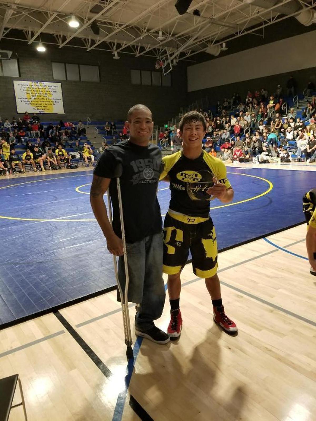 Orting’s Alex Cruz, right, who has signed his letter of intent to wrestle at the University of Virginia next year, poses with Anthony Robles, an ESPYs winner and former national champion wrestler at Arizona State.