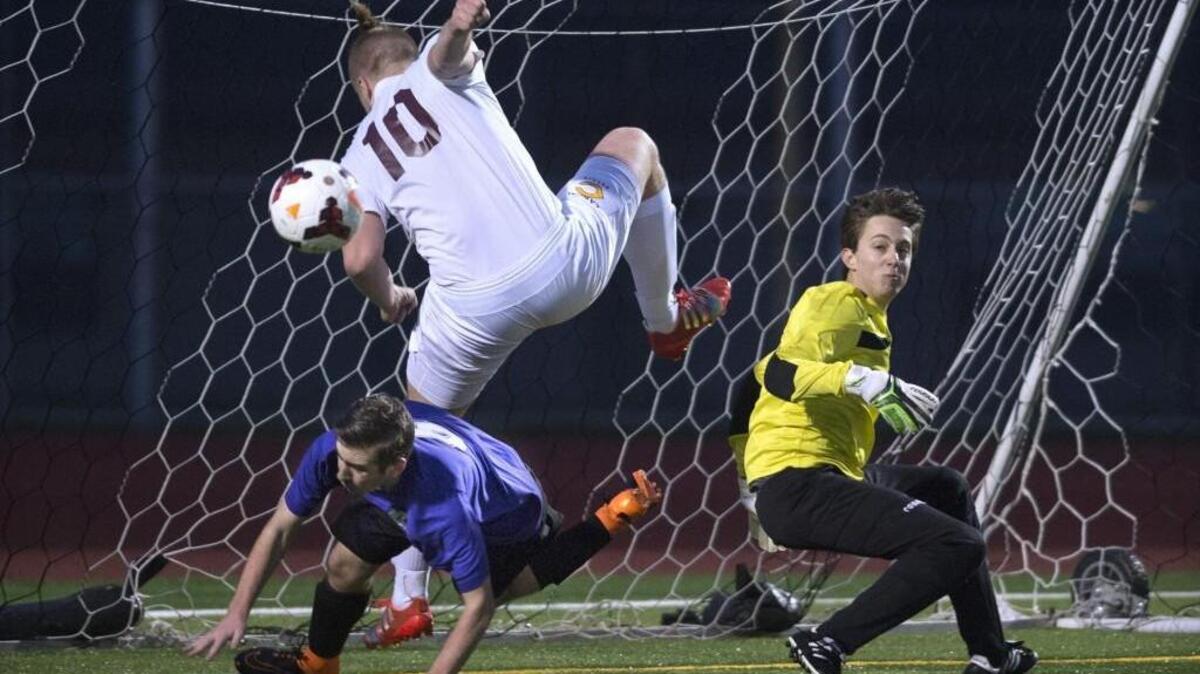 Capital’s Sam Reimertz (10) takes a tumble over North Thurston defender Kody Marcott after Rams goalkeeper Diego Roderiguez (right) knocks the ball away Thursday night at Ingersoll Stadium in Olympia .