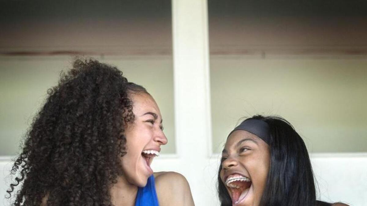 Curtis High School triple jumpers Lexi Ellis and Saudia Heard, right, are close friends share a laugh together at track practice at Curtis High School. Ellis has the fourth-best triple jump in the nation so far this year and hopes to win her first state title, while Heard won the state title two years ago.