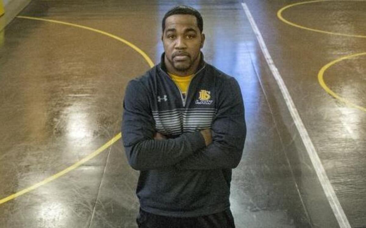 Lincoln High School wrestling coach Greg Ford is shown in December with Will Willsey (left, 220 lbs.), JJ Dixon (right, 182) and Jeramias Sandavol (132).