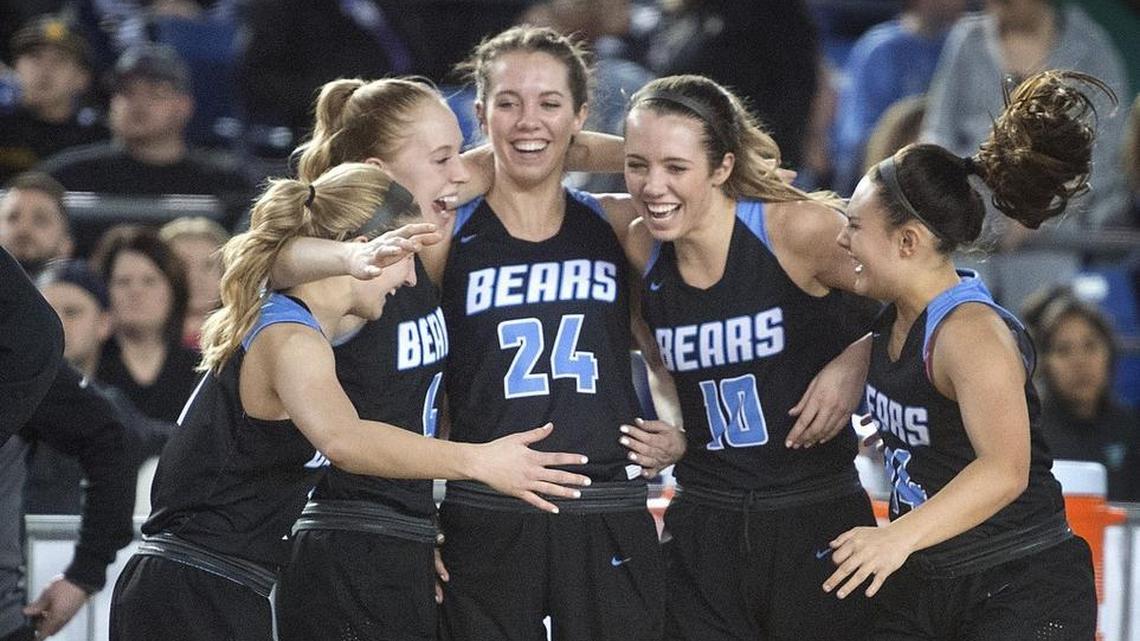 Central Valley starters (from left) Mady Simmelink, Hailey Christopher, Lacie Hull, Lexie Hull and Camryn Skaife celebrate from the bench in the final seconds of the Bears' 70-39 victory over the Woodinville Falcons in Saturday night's 4A girls basketball state championship game in the TacomaDome on March 3, 2018.