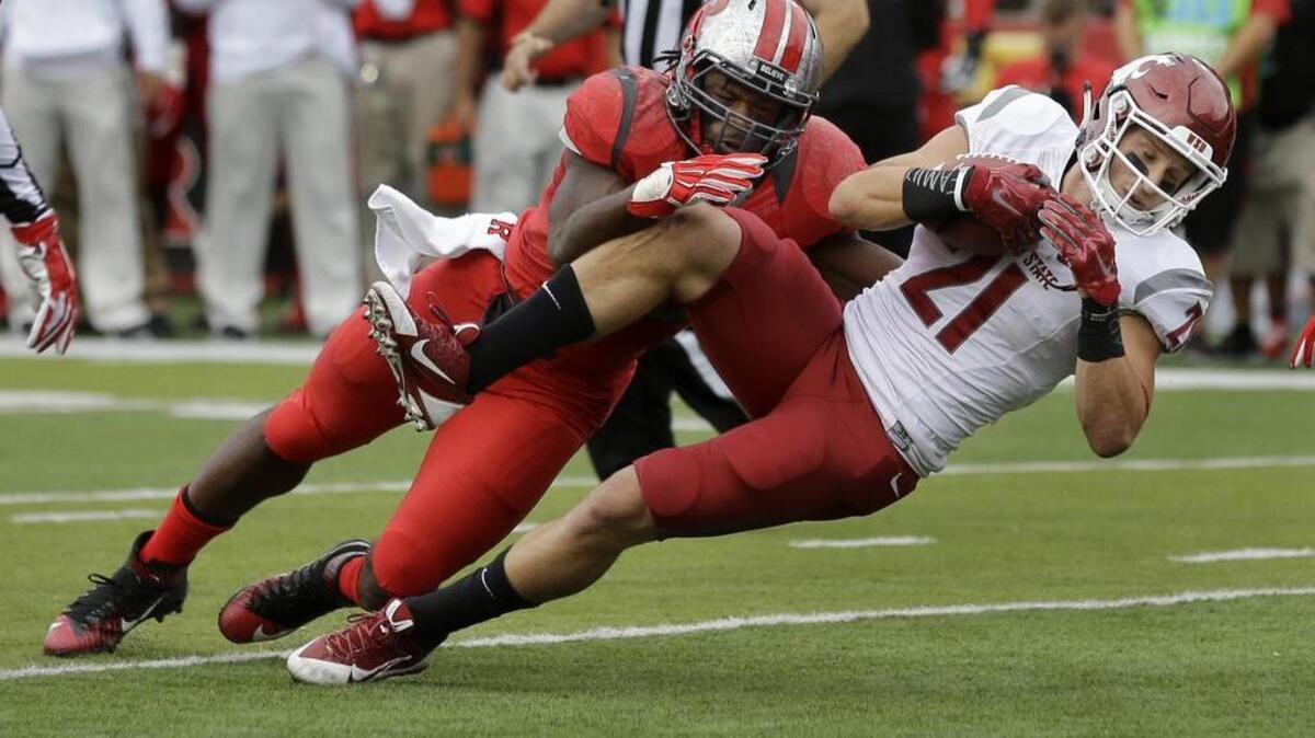 
Washington State’s River Cracraft (21) dives for yardage as Rutgers’ Quentin Gause makes the tackle in the first half Saturday. Cracraft finished with eight receptions for 121 yards, including the winning touchdown with 13 seconds left. 
