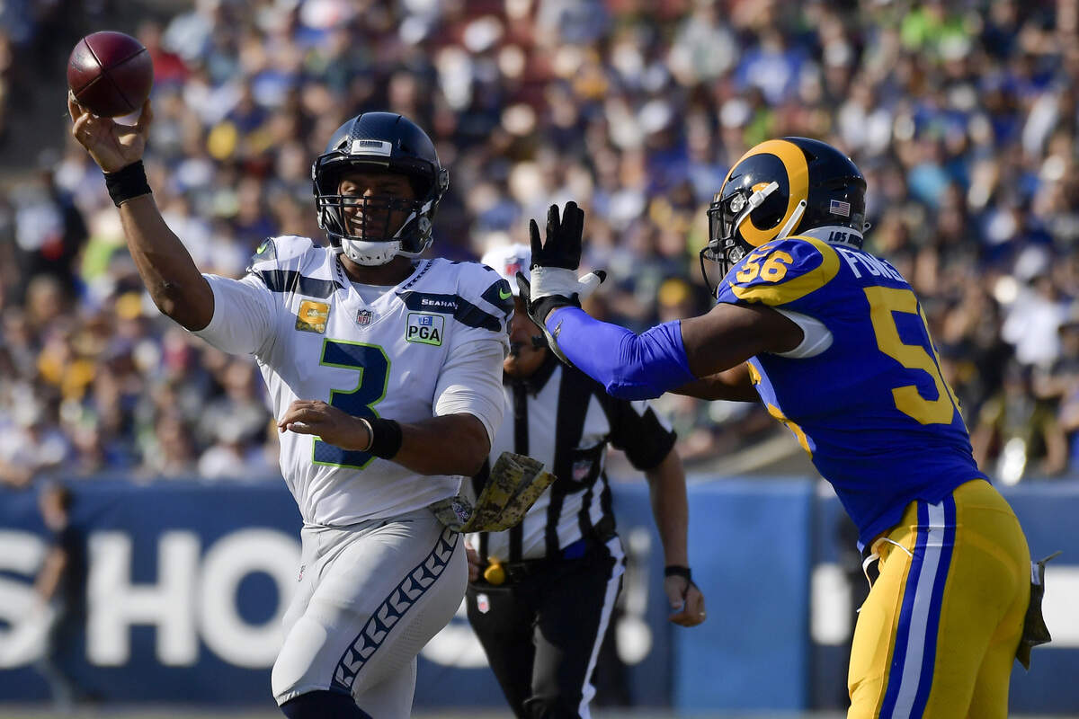 Seattle quarterback Russell Wilson passes under pressure from Los Angeles Rams defensive end Dante Fowler on Sunday during the first half in Los Angeles.