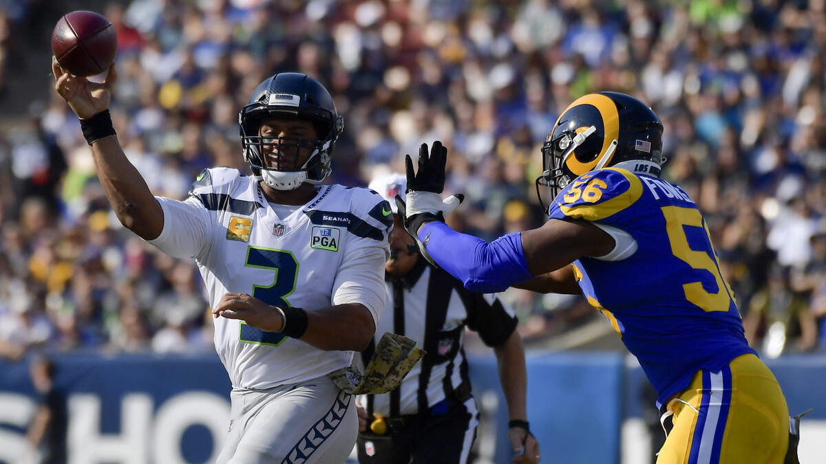 Seattle quarterback Russell Wilson passes under pressure from Los Angeles Rams defensive end Dante Fowler on Sunday during the first half in Los Angeles.