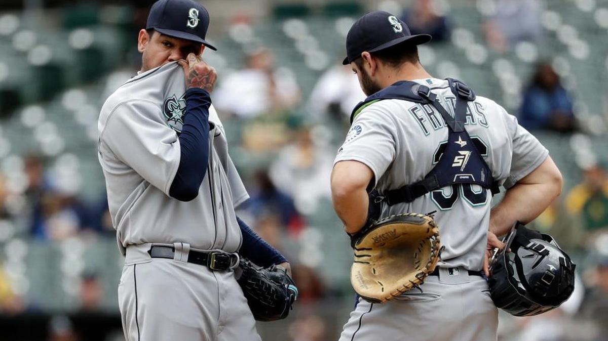 Seattle Mariners starting pitcher Felix Hernandez, left, gets a visit to the mound by catcher David Freitas after Hernandez gave up a two-run double to Oakland Athletics' Stephen Piscotty in the first inning of a baseball game, Thursday, May 24, 2018, in Oakland, Calif. (AP Photo/Marcio Jose Sanchez)