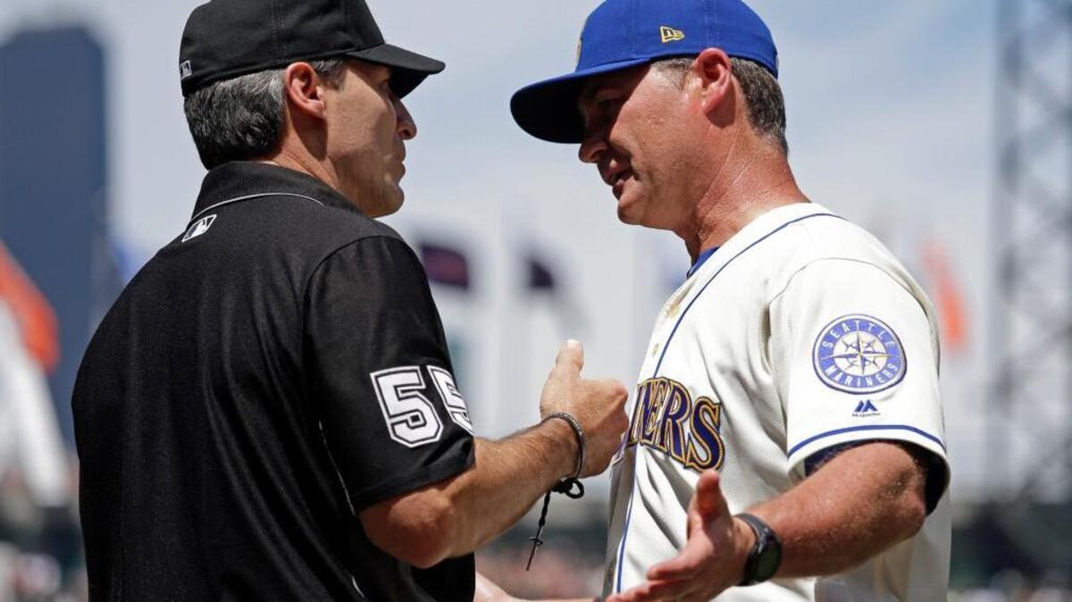 Mariners manager Scott Servais, right, talks with umpire Angel Hernandez on Sunday after a call at home in favor of the Astros in the second inning.