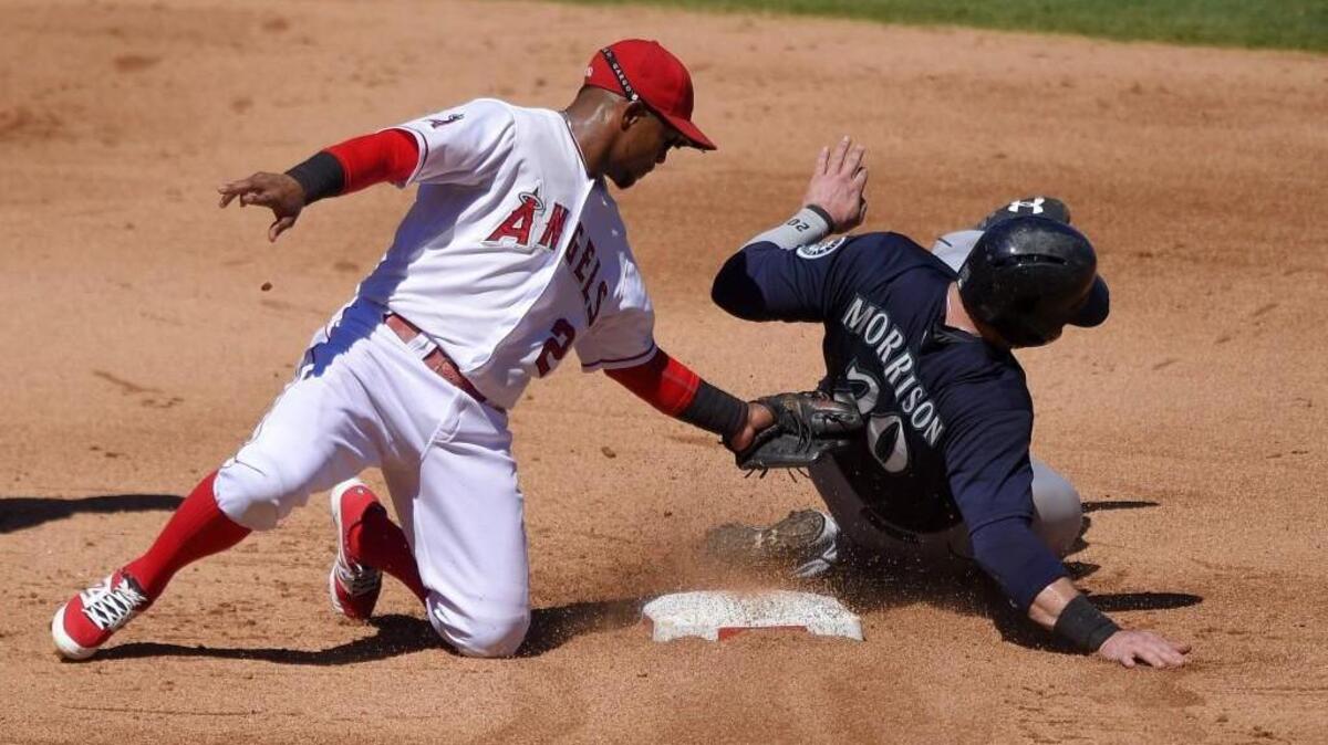 
Logan Morrison, right, of the Mariners is tagged out by Los Angeles Angels shortstop Erick Aybar while trying to steal second in the fifth inning Sunday. Morrison was originally called safe on the play, but it was overturned after review.
