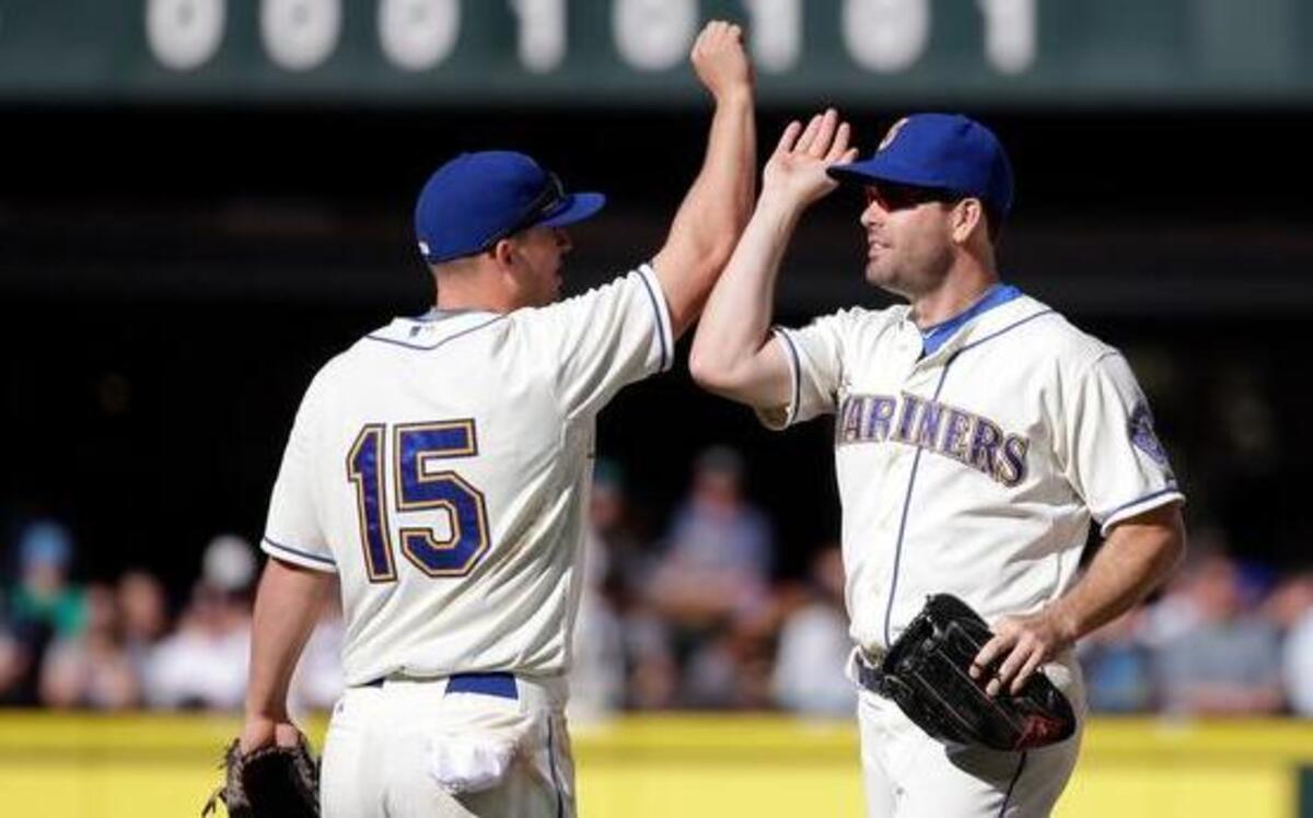 
Mariners third baseman Kyle Seager (15) and outfielder Seth Smith celebrate after winning the final game of the season Sunday, 3-2, against the Athletics at Safeco Field.
